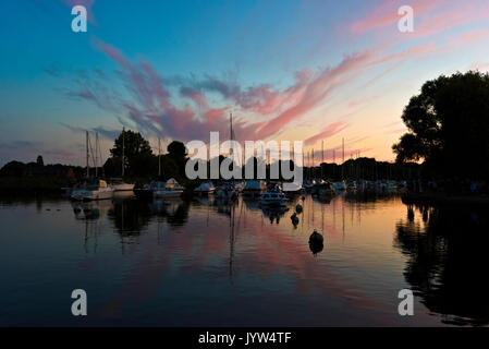 Rote Wolken bei Sonnenuntergang auf dem Fluss Stour am Quamps Christchurch Dorset nieder Stockfoto