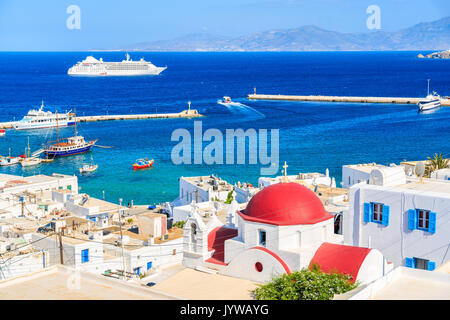 Typische Griechische weiße Kirche mit roten Kuppel und Blick auf den Hafen von Mykonos, Mykonos, Kykladen, Griechenland Stockfoto