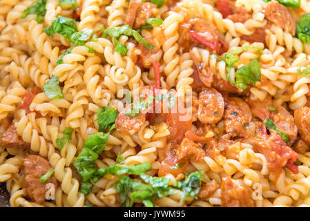 Nahaufnahme von Chorizo Nudeln mit Basilikum und Tomaten Sauce Stockfoto