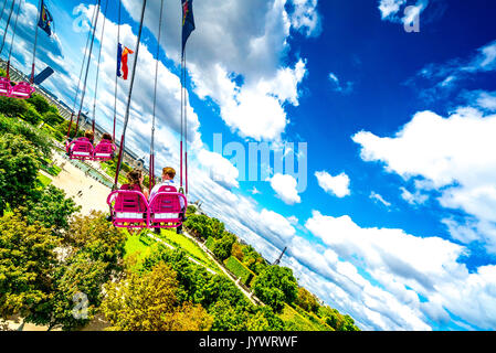 Auf den Schwingenden Sesseln fährt Paar durch die Luft über die Tuileries Gardens. Stockfoto