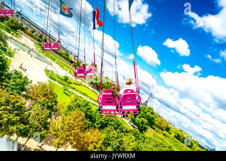 Auf den Schwingenden Sesseln fährt Paar durch die Luft über die Tuileries Gardens. Stockfoto