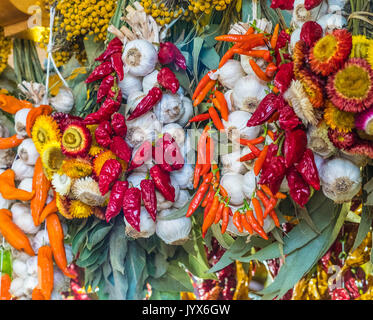 Knoblauch und Pfeffer hängen auf einem lokalen Markt Stockfoto