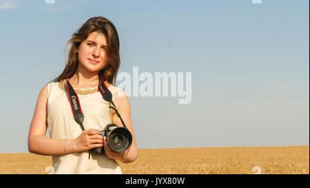 Touristische Reisen Fotograf Foto aufnehmen mit großen schwarzen Kamera auf dem Feld im Sommer Tag Stockfoto