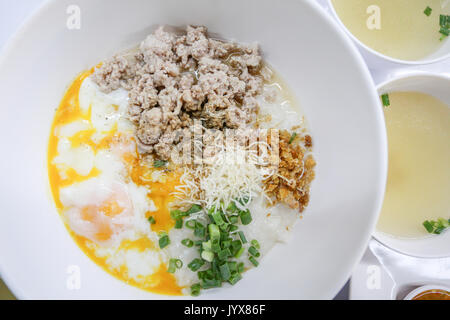 Reisbrei mit gehacktem Schweinefleisch und weich gekochtes Ei Stockfoto