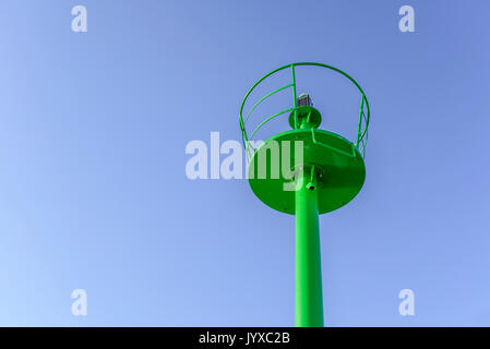 Eine kleine grüne Leuchtturm am Meer. Stockfoto