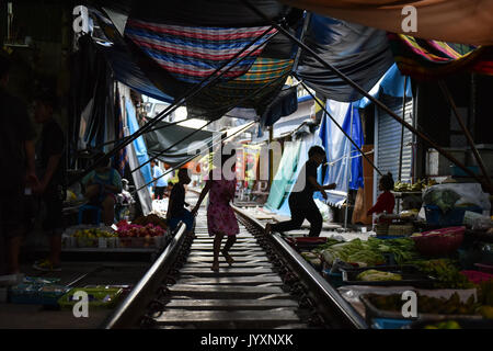 (170821) - MAEKLONG, Aug 21, 2017 (Xinhua) - Kinder spielen auf der Bahnstrecke, die durch Maeklong Markt in der zentralen Provinz Samut Songkhram Thailand, Aug 19, 2017 läuft. In Maeklong Markt, entlang einer Bahnstrecke gebaut, ein Kompromiss zwischen Anbietern und vorbei an S-Bahnen erreicht. Wenn die Rail Track ist klar, stall Besitzer bis Ständen zu werden; noch acht Mal pro Tag, die Markisen und einige der Waren haben, die von der Schiene verschoben werden und machen Weg für ankommende und abfahrende Züge. Die business Stil um Fahrpläne hat Maeklong Markt einer der am meisten uniqu Stockfoto