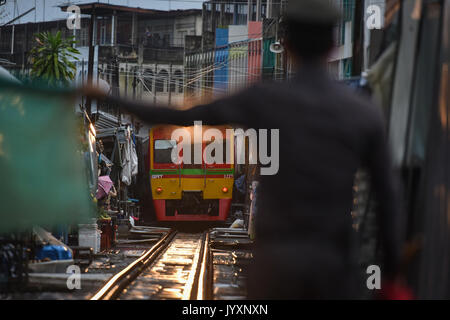 (170821) - MAEKLONG, Aug 21, 2017 (Xinhua) - der Polizist gibt Anweisungen zu einer S-Bahn durch Maeklong Markt in der zentralen Provinz Samut Songkhram Thailand, Aug 19, 2017 läuft. In Maeklong Markt, entlang einer Bahnstrecke gebaut, ein Kompromiss zwischen Anbietern und vorbei an S-Bahnen erreicht. Wenn die Rail Track ist klar, stall Besitzer bis Ständen zu werden; noch acht Mal pro Tag, die Markisen und einige der Waren haben, die von der Schiene verschoben werden und machen Weg für ankommende und abfahrende Züge. Die business Stil um Fahrpläne hat Maeklong M Stockfoto