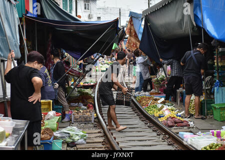(170821) - MAEKLONG, Aug 21, 2017 (Xinhua) - Stall Besitzer weg waren und Falten Markisen vor einem pendlerzug Maeklong Markt in der zentralen Provinz Samut Songkhram Thailand, Aug 18, 2017 passiert. In Maeklong Markt, entlang einer Bahnstrecke gebaut, ein Kompromiss zwischen Anbietern und vorbei an S-Bahnen erreicht. Wenn die Rail Track ist klar, stall Besitzer bis Ständen zu werden; noch acht Mal pro Tag, die Markisen und einige der Waren haben, die von der Schiene verschoben werden und machen Weg für ankommende und abfahrende Züge. Die business Stil um Fahrpläne hat Maeklong M Stockfoto