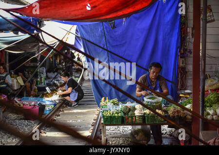 (170821) - MAEKLONG, Aug 21, 2017 (Xinhua) - ein Stall Eigentümer bereitet sich für Business bei Maeklong Markt in der zentralen Provinz Samut Songkhram Thailand, Aug 19., 2017. In Maeklong Markt, entlang einer Bahnstrecke gebaut, ein Kompromiss zwischen Anbietern und vorbei an S-Bahnen erreicht. Wenn die Rail Track ist klar, stall Besitzer bis Ständen zu werden; noch acht Mal pro Tag, die Markisen und einige der Waren haben, die von der Schiene verschoben werden und machen Weg für ankommende und abfahrende Züge. Die business Stil um Fahrpläne hat Maeklong Markt einer der einzigartigsten Märkte in T Stockfoto