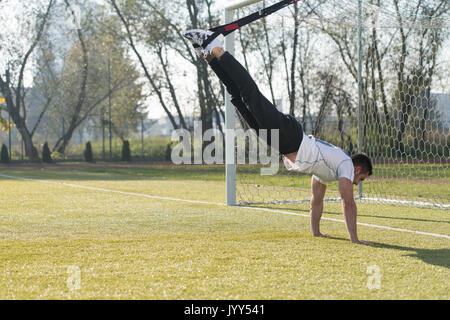 Attraktiver Mann tun Crossfit mit Trx Fitness Bänder in Stadt Park - Ausbildung und Training für Ausdauer - Gesunder Lebensstil Konzept Outdoor Stockfoto