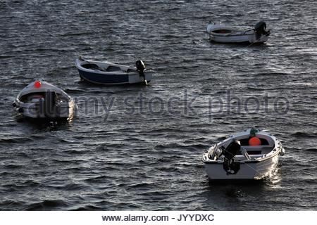 Vier kleine Boote liegen in schönen Abend Licht auf dem Wasser am Rosses Point, County Sligo, Irland. Stockfoto