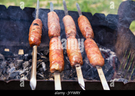 Schweinefleisch, Wurst vom Grill auf einem Kohlen. Outdoor-Würstchen grillen. BBQ auf Kohlenbecken. Stockfoto