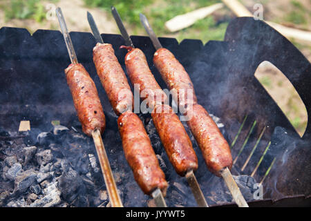 Rind Würstchen gegrillt auf Kohlen. Outdoor kielbasa Grill. Barbecue auf brazier. Stockfoto