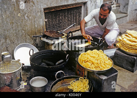 Mann Kochen und Essen auf der Straße verkaufen, Ahmedabad, Gujarat, Indien. Stockfoto