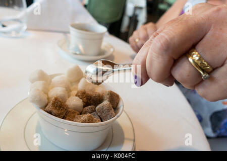 Frau unter raw Brown Sugar Cubes mit silbernen Zange an Roux an der Landau das Langham Hotel, 1 C Portland Pl, Marylebone, London W1B 1JA, Großbritannien Stockfoto