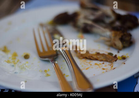 Eine Platte mit ein paar Reste nach einer Mahlzeit mit Couscous, Huhn und yogurtsauce Stockfoto