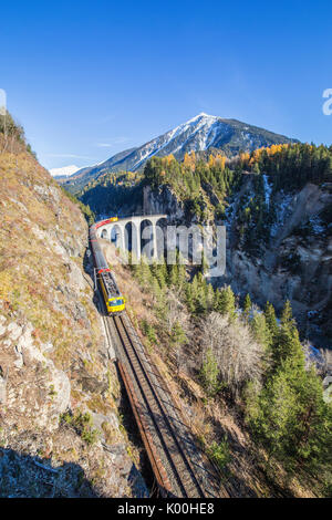 Bernina Express durchläuft Landwasser Viadukt umgeben von bunten Wäldern Kanton Graubünden Schweiz Europa Stockfoto