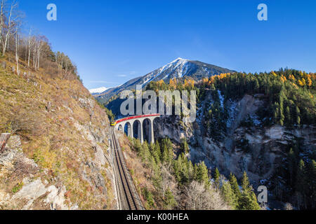 Bernina Express durchläuft Landwasser Viadukt umgeben von bunten Wäldern Kanton Graubünden Schweiz Europa Stockfoto