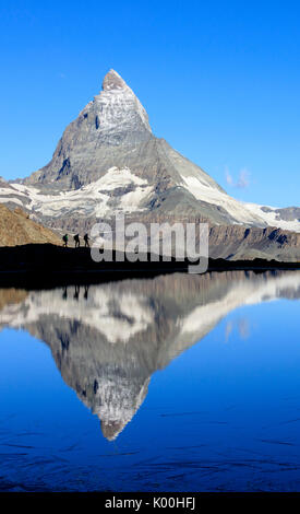 Wanderer bewundern das Matterhorn spiegelt sich im See Stellisee Zermatt Kanton Wallis Walliser Alpen der Schweiz Europas Stockfoto