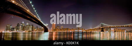 Einen atemberaubenden Blick bei Nacht auf die Skyline von New York vom Ufer des Hudson River von Brooklyn Bridge überquert. New York. USA. Stockfoto