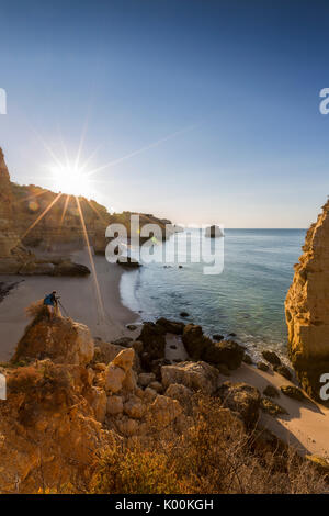 Erste Sonnenstrahlen auf den Klippen und türkisfarbenem Wasser am Praia da Marinha Caramujeira Lagoa Gemeinde Algarve Portugal Europa Stockfoto