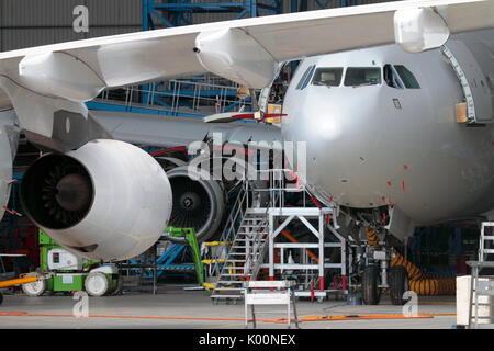 Passenger Jet Flugzeuge gewartet. in einer geschäftigen Flugzeughangar. Aviation Engineering als Faktor für die wirtschaftliche Entwicklung und das Wachstum des BIP Stockfoto