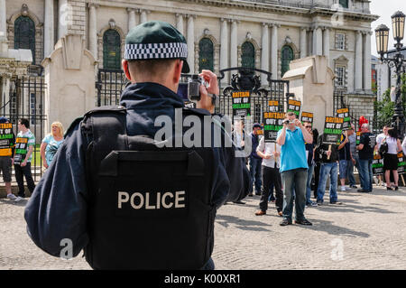 26 Juni 2010, Belfast. Polizisten Video und Foto Eirigi Mitglieder während einer Demonstration. Stockfoto