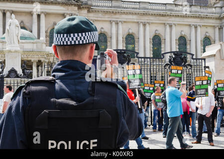 26 Juni 2010, Belfast. Polizisten Video und Foto Eirigi Mitglieder während einer Demonstration. Stockfoto