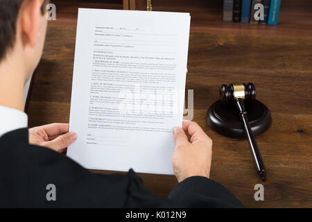 Hohe Betrachtungswinkel der männlichen Richter lesen Rechtliche Dokumente am Schreibtisch im Gerichtssaal Stockfoto