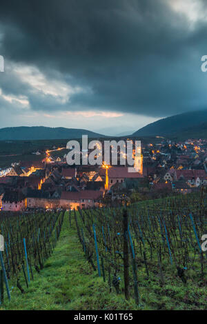 Wolken und Licht auf die alte Stadt Riquewihr, umrahmt von grünen Weinbergen Haut-Rhin Abteilung Grand Est Elsass Frankreich Europa Stockfoto