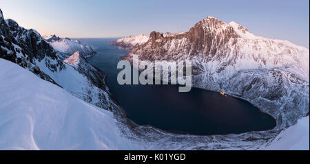 Draufsicht auf den schneebedeckten Gipfeln umliegenden Fjordgard umrahmt das gefrorene Meer bei Sonnenuntergang Ornfjorden Senja Tromsø Norwegen Europa Stockfoto