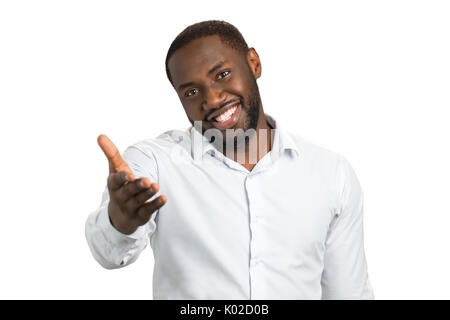 Dunkelhäutige Mann mit einer Hand ausgestreckt. Lächelnd bärtiger Mann an jemand mit ausgestreckter Hand zeigen. Stockfoto