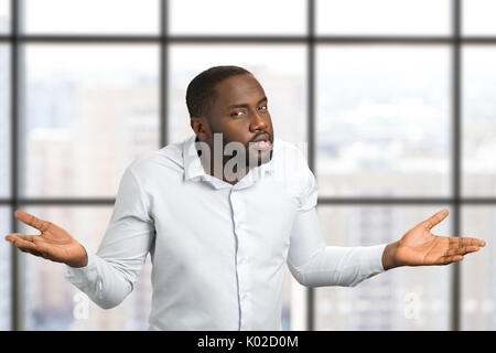 Schwarzer Mann mit Händen in den verschiedenen Seiten. Mann mit den Händen an den Seiten des Körpers erhöht. Mimik und Körpersprache. Stockfoto