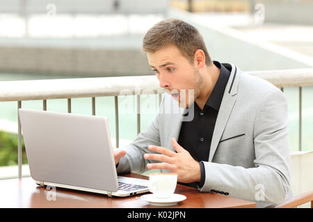 Erstaunt Geschäftsmann erhalten gute Nachrichten in einem Café sitzen Stockfoto