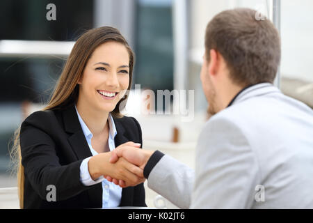 Zwei Führungskräfte treffen und Handshaking in einem Café sitzen Stockfoto