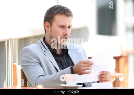 Traurig executive Lesen schlechte Nachrichten in einem Brief in einem Café sitzen Stockfoto