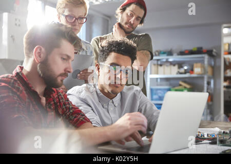 Ernst, konzentrierte sich Designer auf Laptop Arbeiten in der Werkstatt Stockfoto