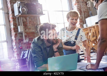 Lächelnd Designer treffen auf Laptop in der Werkstatt Stockfoto