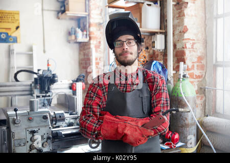 Portrait zuversichtlich Schweißer mit Schweißbrenner in Werkstatt Stockfoto