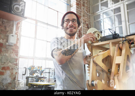 Männliche Designer mit Tattoos arbeiten an Prototypen in der Werkstatt Stockfoto
