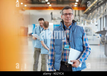 Portrait zuversichtlich männlichen Vorgesetzten mit Klemmbrett in der Factory Stockfoto