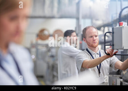 Männliche Arbeiter mit Maschinen Control Panel in der Factory Stockfoto