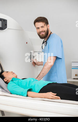 Junger Arzt An CT-Scan auf weibliche Patienten Stockfoto