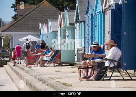 Genießen Sie die Sonne außerhalb der holzhütten am Brüder Cliff, Christchurch, Dorset Stockfoto