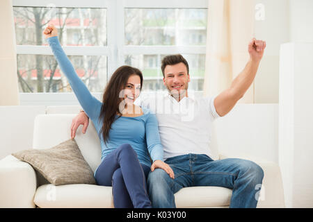 Portrait von Ekstatischen Paar auf der Couch zu Hause sitzen Stockfoto