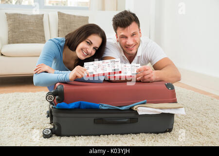 Portrait von glückliches junges Paar Verpackung Gepäck zeigen Bordkarte Stockfoto