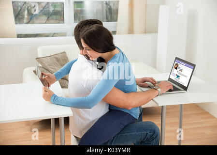 Porträt eines jungen Paares zu Hause mit digitalen Tablet-PC und Laptop Stockfoto