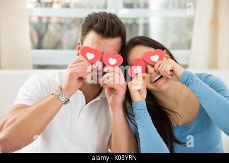 Junge glückliches Paar, die Augen mit dem roten Herzen Stockfoto