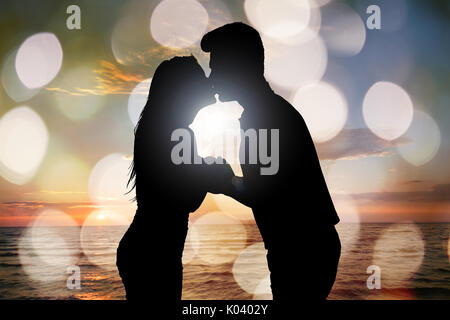 Silhouette von Paar küssen Vor Meer am Strand bei Sonnenuntergang Stockfoto