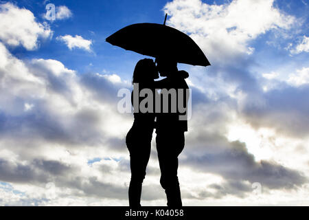 Silhouette von Liebespaar unter dem Dach gegen bewölkter Himmel Stockfoto